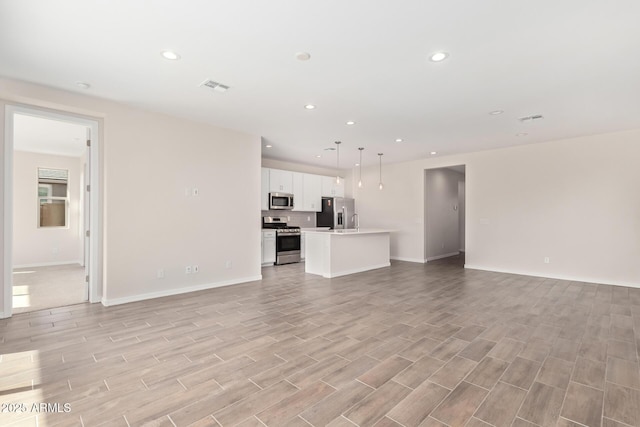 unfurnished living room featuring sink