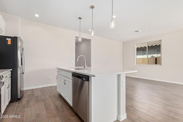 kitchen featuring white cabinetry, sink, hanging light fixtures, a kitchen island with sink, and stainless steel appliances