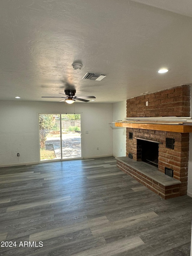 unfurnished living room with a textured ceiling, a brick fireplace, hardwood / wood-style floors, and ceiling fan