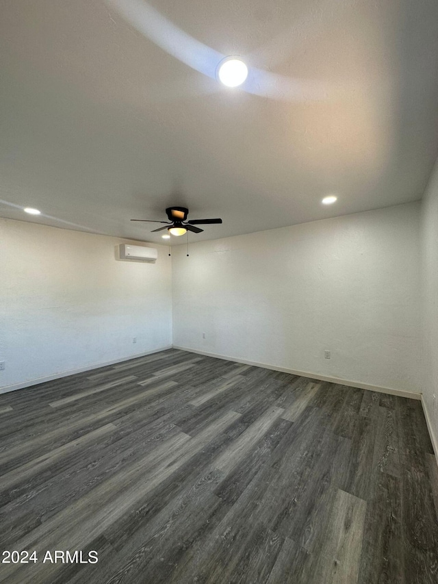 unfurnished room featuring a wall mounted AC, wood-type flooring, and ceiling fan