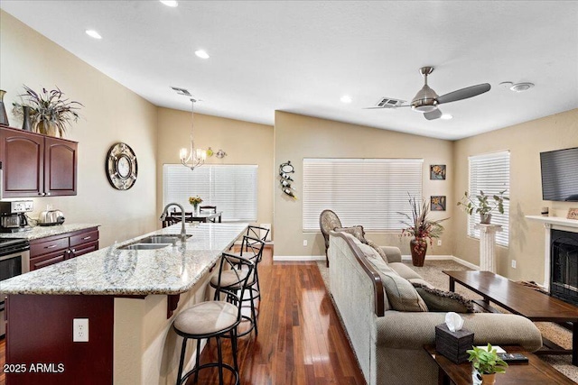 living room featuring sink, ceiling fan with notable chandelier, dark hardwood / wood-style floors, and lofted ceiling