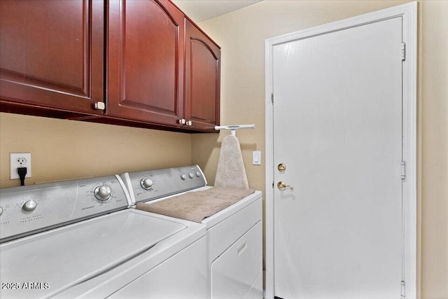 laundry room featuring washer and dryer and cabinets