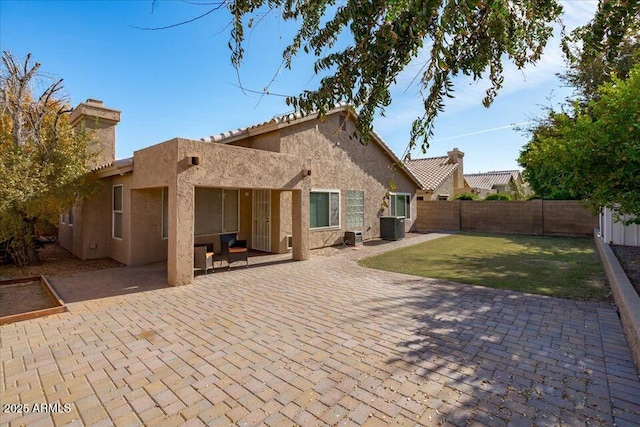 back of house with central AC unit, a patio area, and a yard