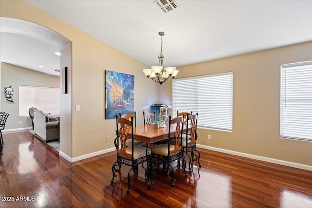 dining area featuring a notable chandelier, dark hardwood / wood-style floors, and lofted ceiling