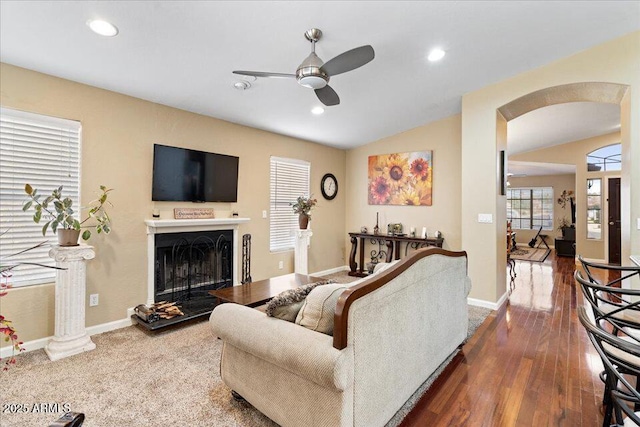 living room with dark hardwood / wood-style floors, ceiling fan, and lofted ceiling