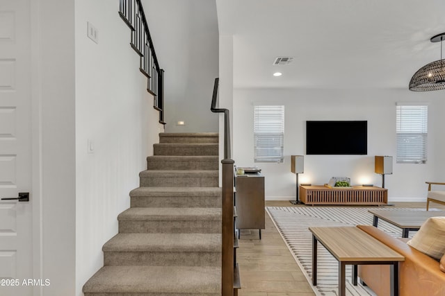 stairway featuring recessed lighting, visible vents, baseboards, and wood finished floors