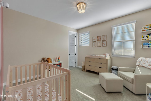 carpeted bedroom featuring a nursery area