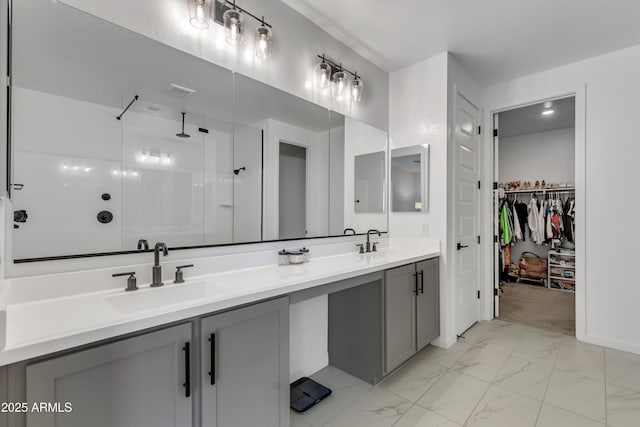 full bathroom with a walk in shower, marble finish floor, double vanity, and a sink