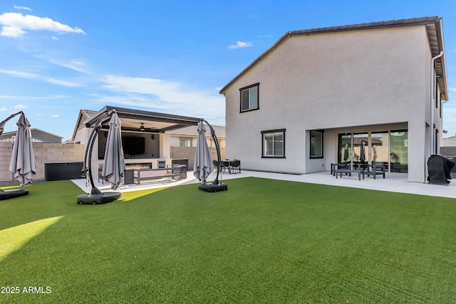 back of property with a lawn, a patio area, fence, and stucco siding