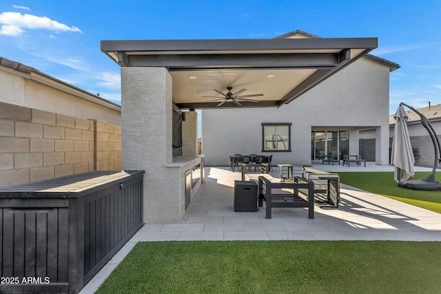 back of property with a ceiling fan, a patio area, fence, and stucco siding