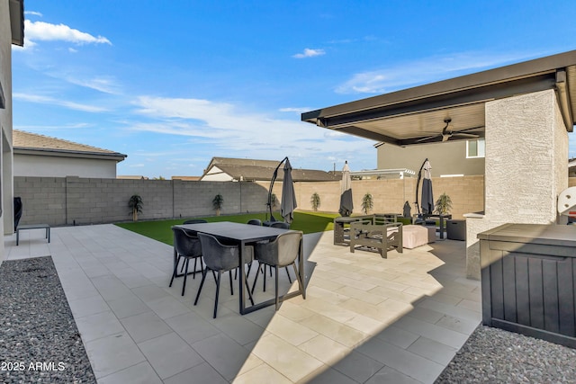 view of patio featuring a fenced backyard, ceiling fan, and outdoor dining space