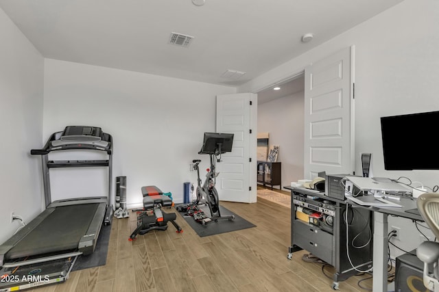 exercise room with visible vents and wood finished floors