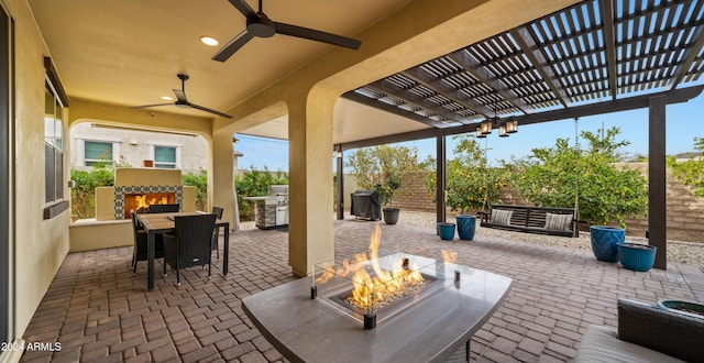 view of patio featuring ceiling fan, an outdoor kitchen, and an outdoor fireplace