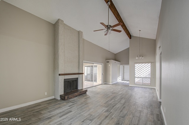 unfurnished living room featuring beamed ceiling, a large fireplace, wood-type flooring, and high vaulted ceiling