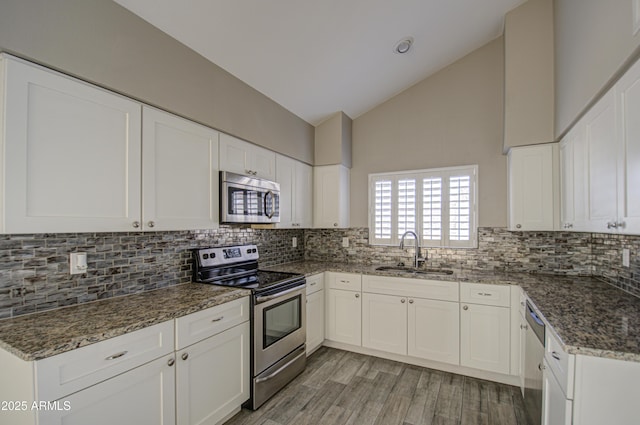 kitchen featuring sink, dark stone counters, white cabinets, and appliances with stainless steel finishes