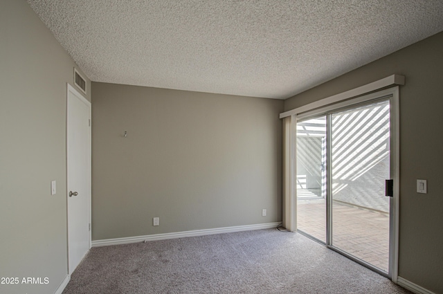 spare room featuring carpet and a textured ceiling