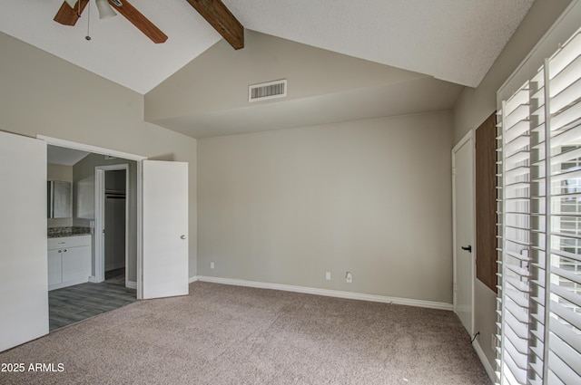 unfurnished bedroom featuring high vaulted ceiling, ensuite bathroom, beamed ceiling, and carpet flooring