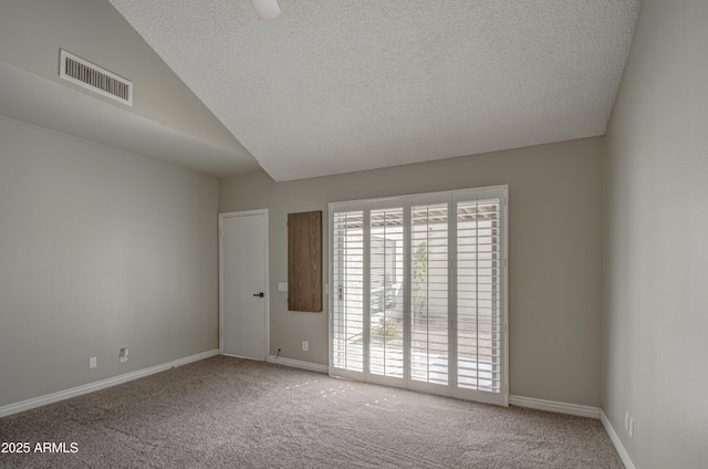 empty room featuring ceiling fan, lofted ceiling, carpet floors, and a textured ceiling