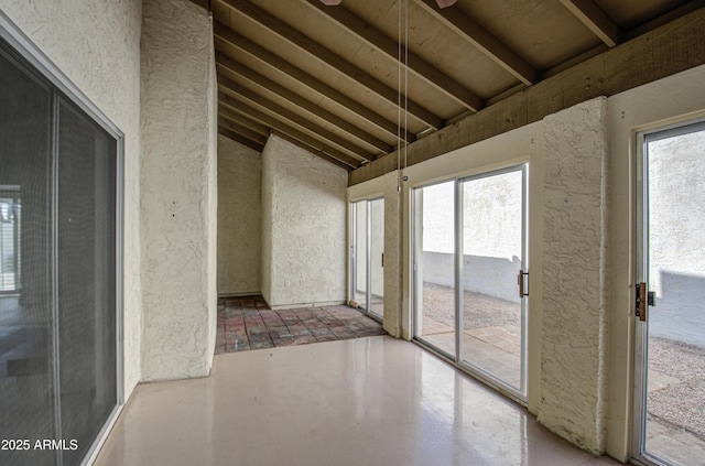 unfurnished sunroom featuring vaulted ceiling