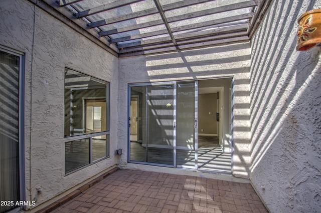 entrance to property with a pergola and a patio