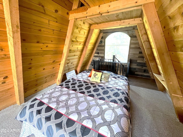 carpeted bedroom with wooden walls, vaulted ceiling with beams, and wood ceiling