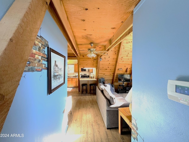 corridor with light wood-style flooring and wood walls