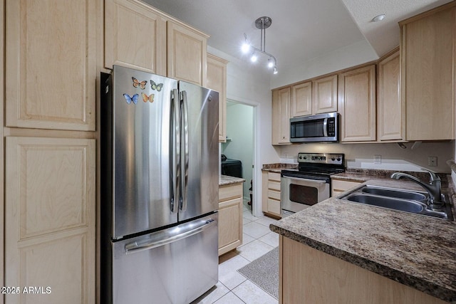 kitchen featuring sink, light brown cabinets, hanging light fixtures, and appliances with stainless steel finishes