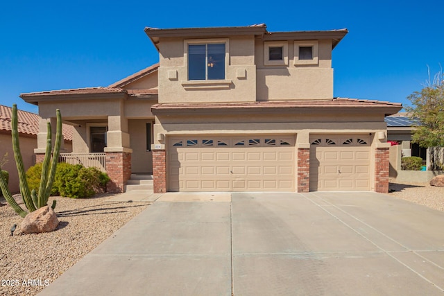 prairie-style home with driveway, brick siding, an attached garage, and stucco siding