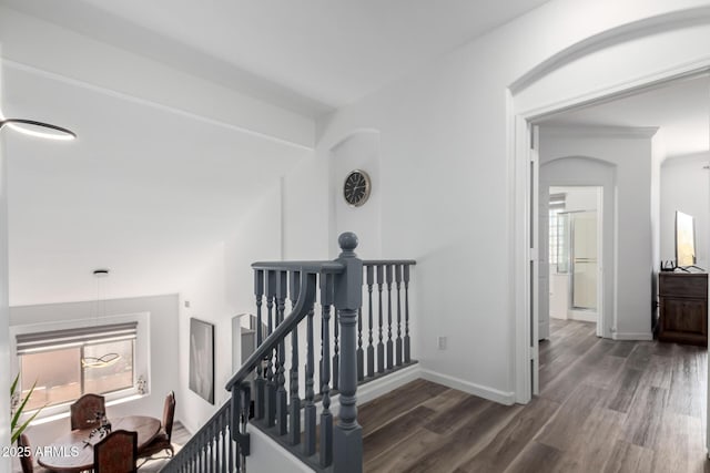 hall with baseboards, wood finished floors, and an upstairs landing