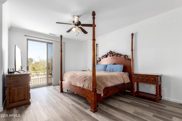 bedroom featuring access to exterior, crown molding, baseboards, and wood finished floors