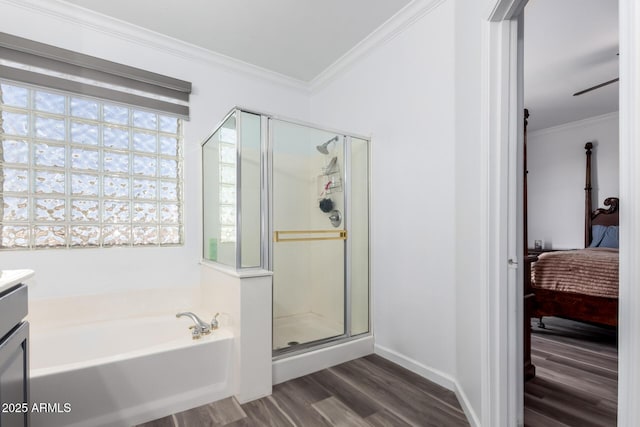 bathroom with wood finished floors, ensuite bathroom, a garden tub, crown molding, and a shower stall