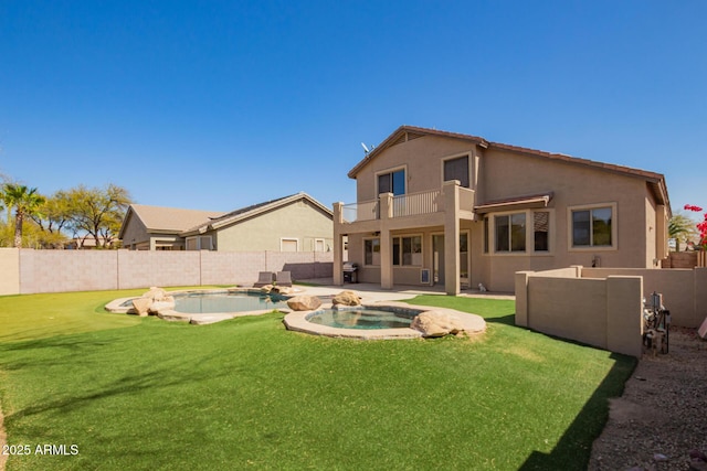 back of house featuring a fenced in pool, a balcony, a fenced backyard, an in ground hot tub, and stucco siding