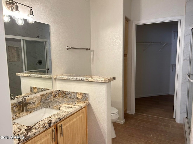 15225 N 100th St Unit 1220, Scottsdale, AZ 85260 - bathroom with a walk in closet, a shower stall, toilet, and wood finished floors