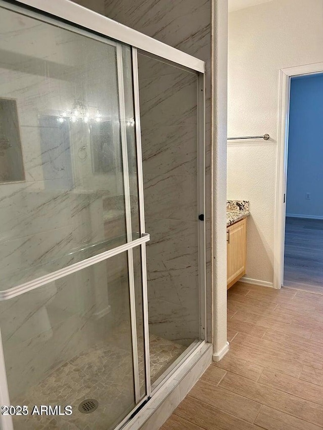 15225 N 100th St Unit 1220, Scottsdale, AZ 85260 - bathroom featuring baseboards, a shower stall, wood finished floors, and vanity