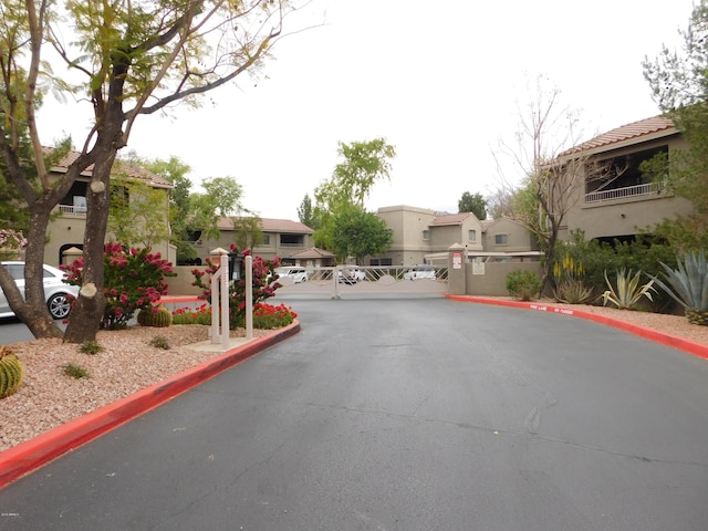 15225 N 100th St Unit 1220, Scottsdale, AZ 85260 - view of road featuring a residential view, a gate, a gated entry, and curbs