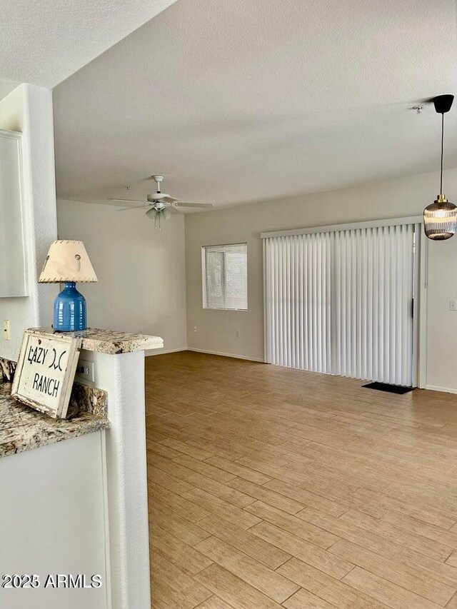 15225 N 100th St Unit 1220, Scottsdale, AZ 85260 - unfurnished living room featuring ceiling fan, light wood-type flooring, and a textured ceiling