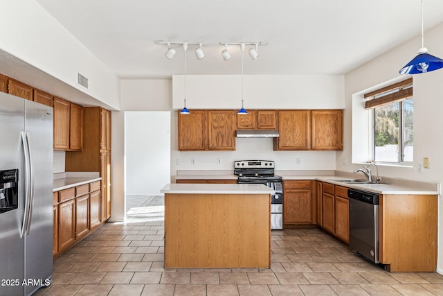 kitchen featuring stainless steel appliances, sink, a kitchen island, and decorative light fixtures