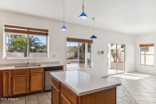 kitchen featuring dishwasher, a center island, sink, hanging light fixtures, and light tile patterned floors