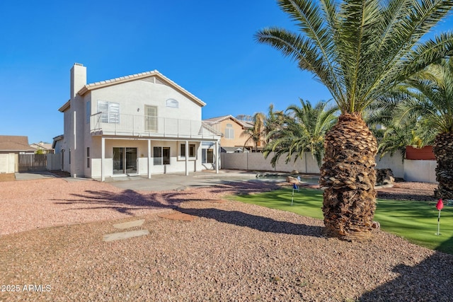 rear view of property with a balcony and a patio