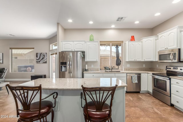 kitchen featuring sink, a center island, white cabinets, and appliances with stainless steel finishes