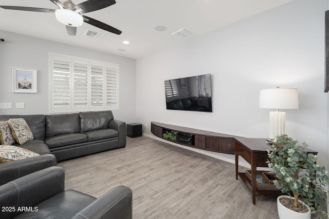 living area featuring a ceiling fan, baseboards, visible vents, and wood finished floors