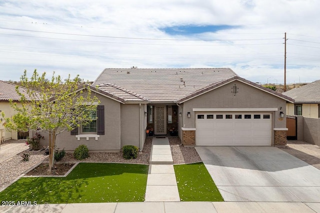 view of front of home with a garage, stucco siding, concrete driveway, and a tiled roof