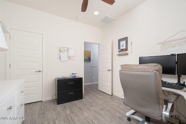 office space with a ceiling fan, baseboards, visible vents, and light wood finished floors