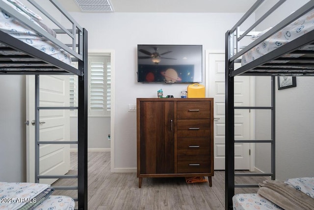 bedroom featuring baseboards, visible vents, and wood finished floors