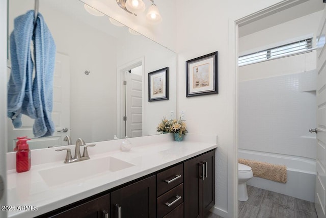 full bath featuring shower / bathtub combination, vanity, toilet, and wood finished floors