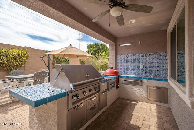 view of patio / terrace with area for grilling, ceiling fan, a fenced backyard, grilling area, and outdoor dining area