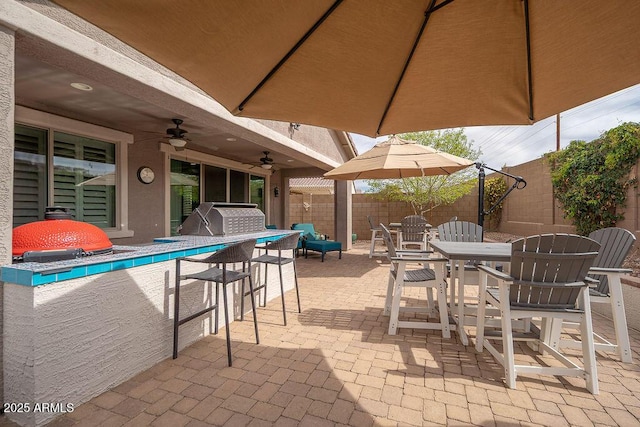 view of patio with outdoor dining space, a grill, fence, ceiling fan, and an outdoor pool