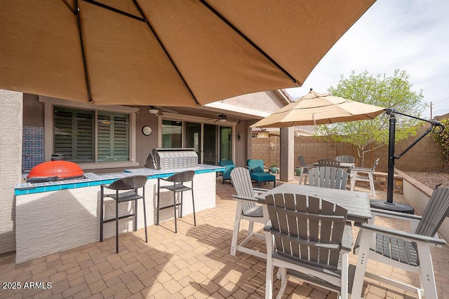 view of patio / terrace with ceiling fan, outdoor dining space, and fence