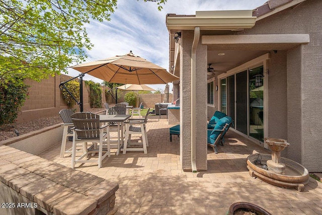 view of patio / terrace with outdoor dining space, a fenced backyard, and ceiling fan