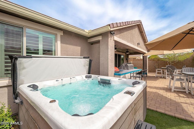 view of patio / terrace featuring outdoor dining area, fence, and a hot tub